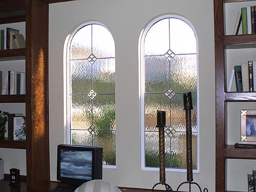 The horizontal lines in these windows continue the horizontal scheme of the room, while the arches bring an added element to this study